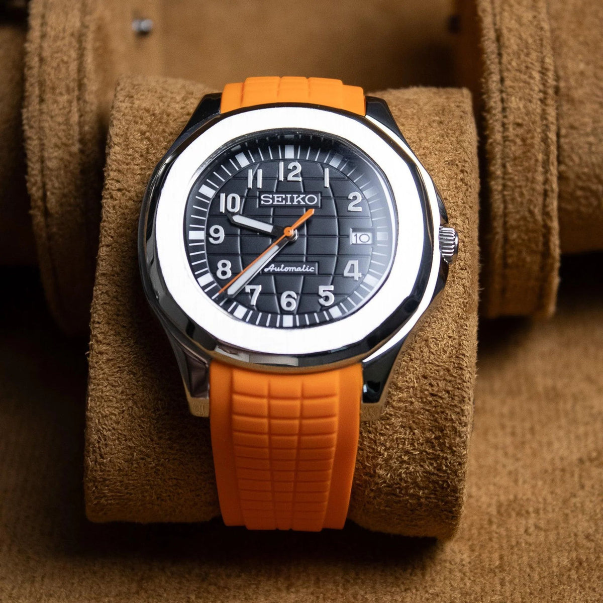 Montre automatique ModTime de style Aquanaut — configuration orange (NH35), bracelet orange, cadran numéroté, vue de face dans un étui beige