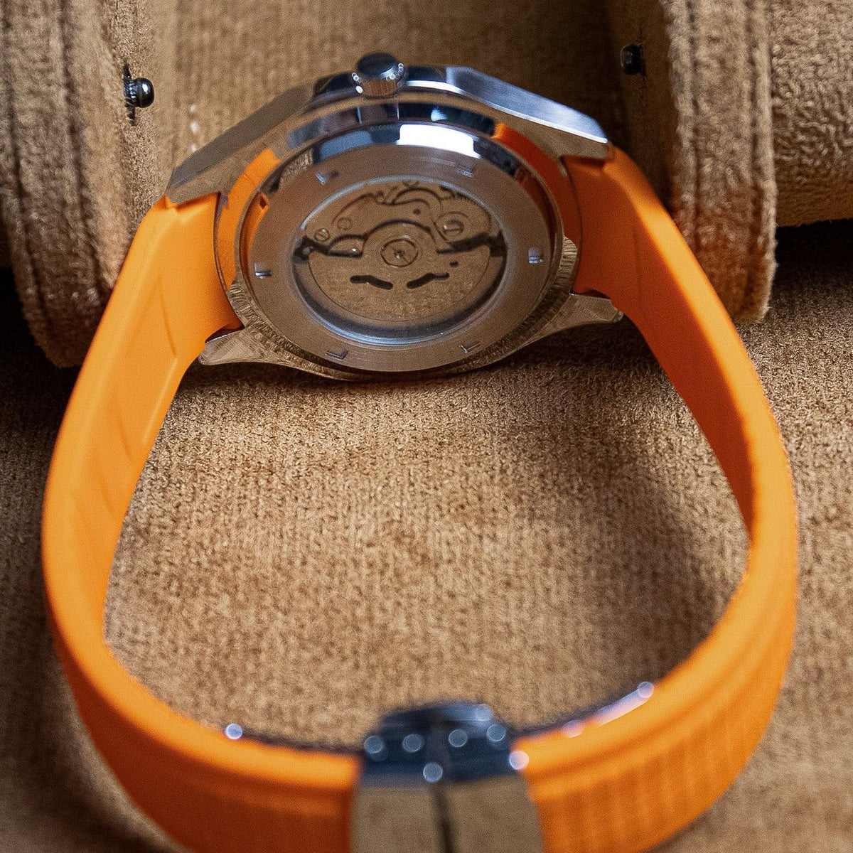 Montre automatique ModTime de style Aquanaut — configuration orange (NH35), bracelet orange, fond de boîtier transparent, vue arrière dans un étui beige