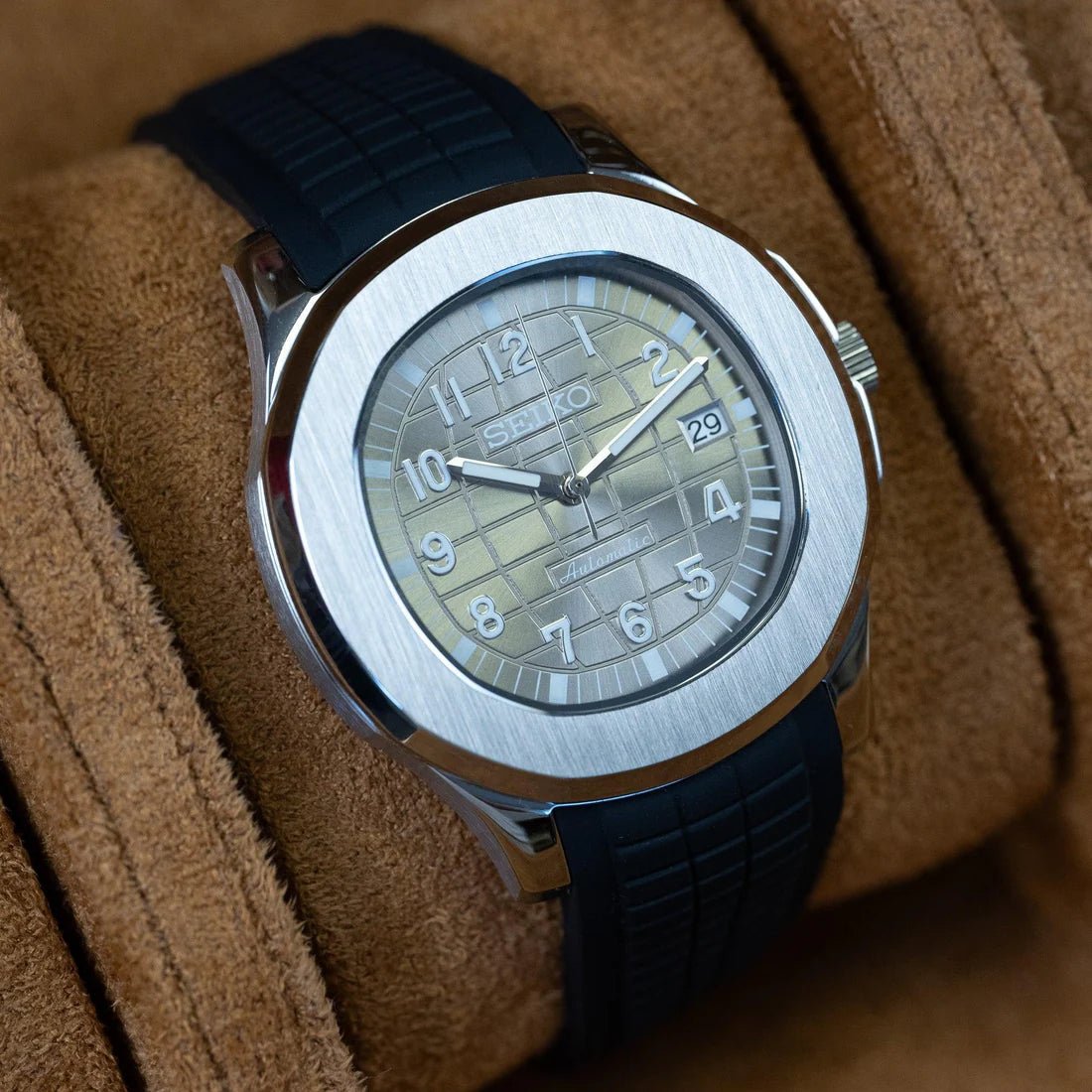 Montre automatique ModTime de style Aquanaut — configuration «Silver Back» (NH35), bracelet noir, lunette brossée, vue en biais sur un coussin