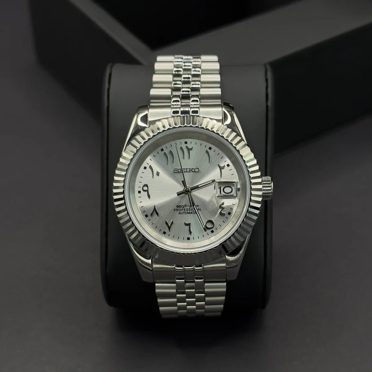 Montre automatique de style Datejust — configuration cadran argenté à chiffres arabes (NH35) avec maillons sur plusieurs rangées aux tons argentés, vue de face sur un coussin noir