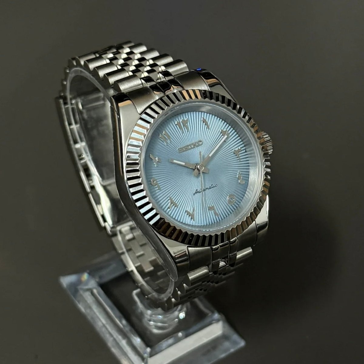 Montre automatique ModTime de style Datejust — configuration argentée et bleu clair, à chiffres arabes (NH35), bracelet aux tons argentés, lunette cannelée, vue en biais côté gauche