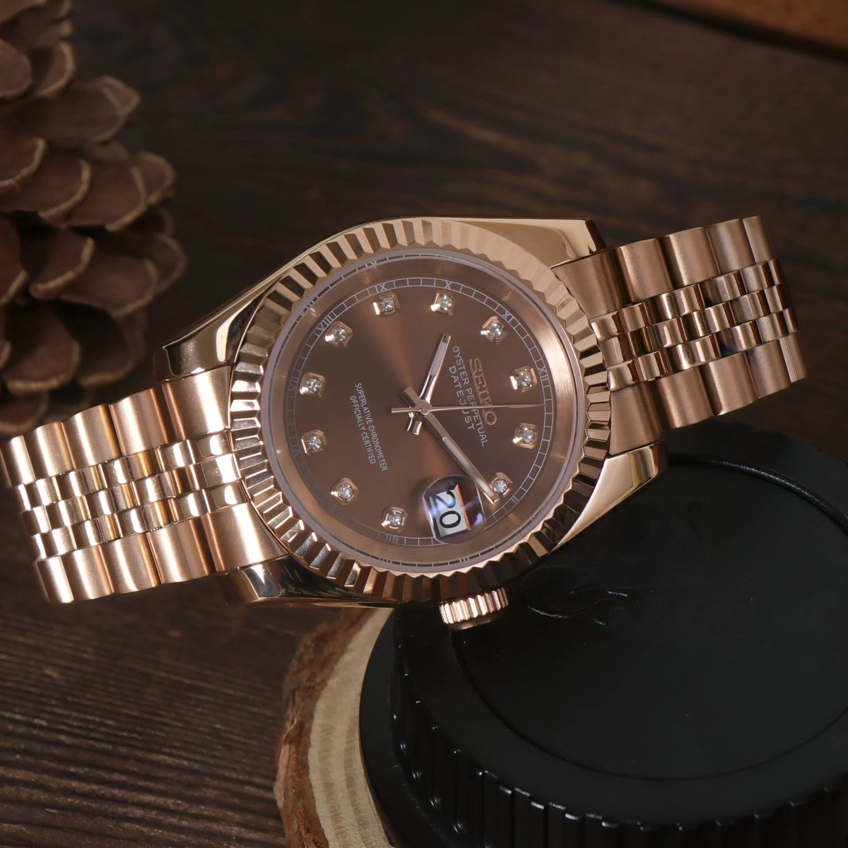 Montre automatique de style Datejust — configuration aux tons or rose et marron chocolat (NH35), cadran marron, lunette cannelée, sur le côté sur du bois