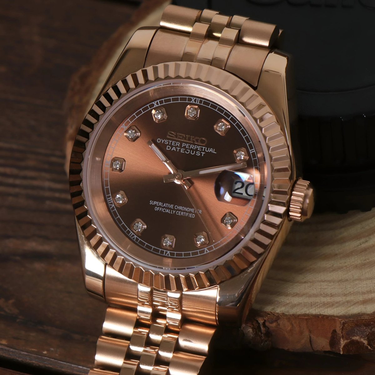 Montre automatique de style Datejust — configuration aux tons or rose et marron chocolat (NH35), cadran marron, index romains aux quarts, sur une tranche de bois