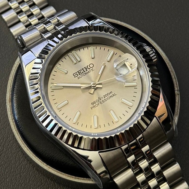 Montre automatique de style Datejust — configuration argentée, cadran champagne (NH35) avec index bâtons aux tons argentés, sur un support rond