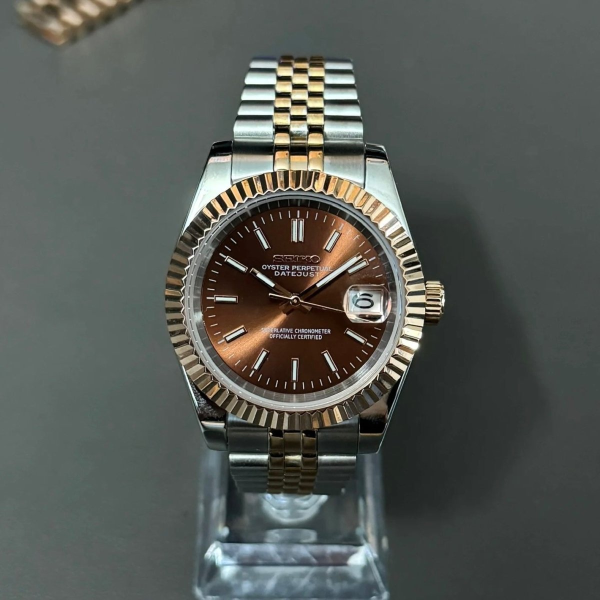 Montre automatique de style Datejust — configuration bicolore, cadran marron chocolat (NH35) avec cadran marron, lunette cannelée, vue de face sur un support