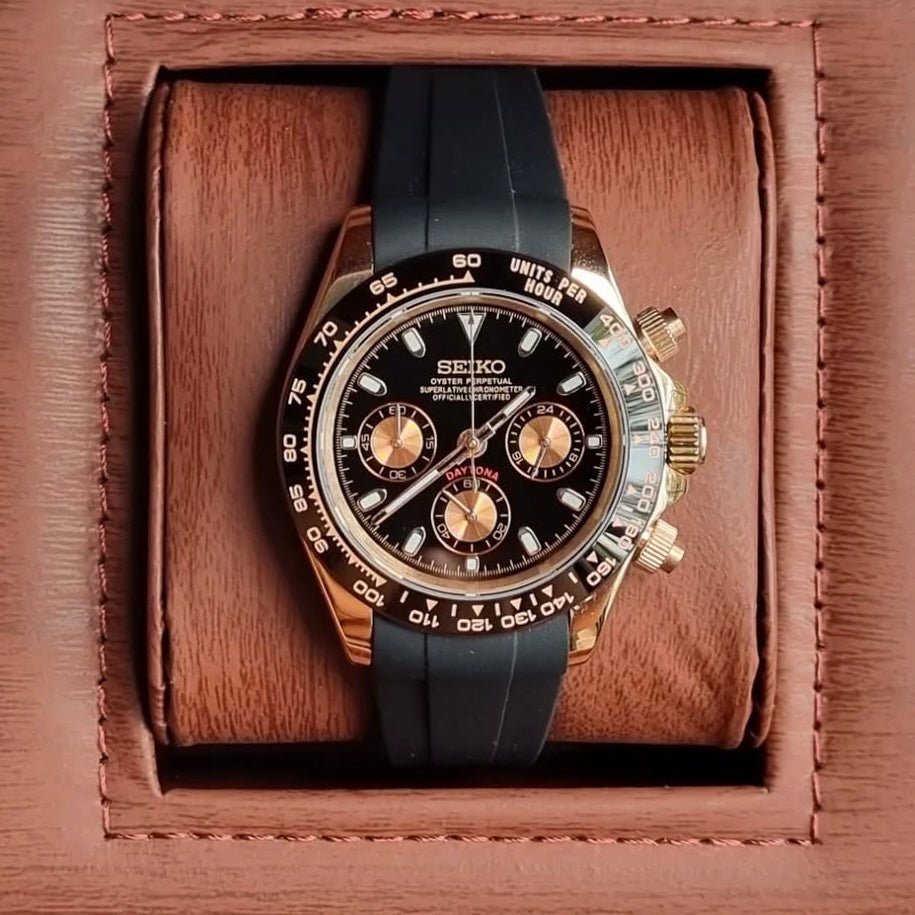 Chronographe méca-quartz ModTime de style Daytona — configuration aux tons or rose et noirs (VK63), cadran noir, lunette tachymétrique, vue dans une boîte