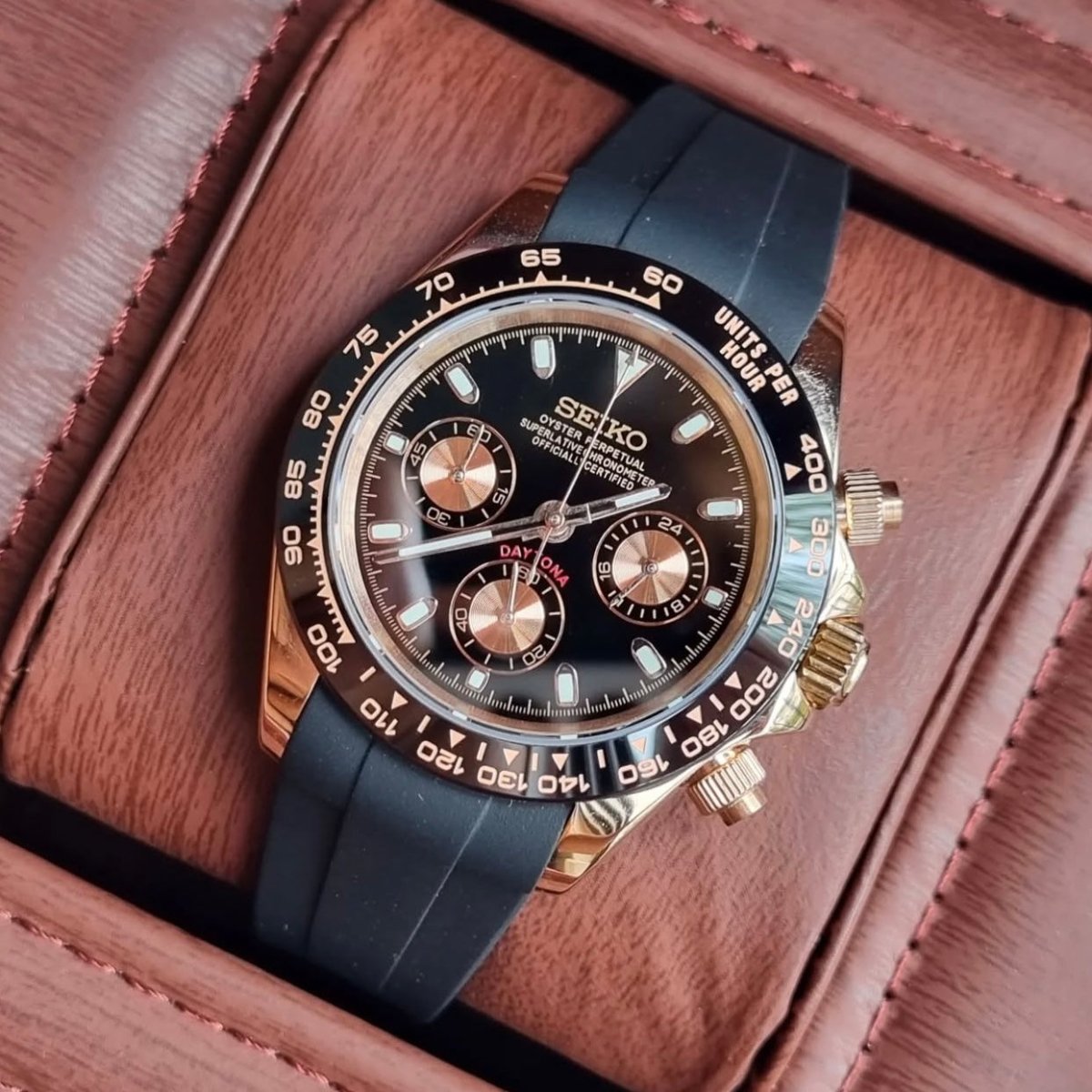 Chronographe méca-quartz ModTime de style Daytona — configuration aux tons or rose et noirs (VK63), bracelet noir, couronne et poussoirs, vue depuis le dessus en biais