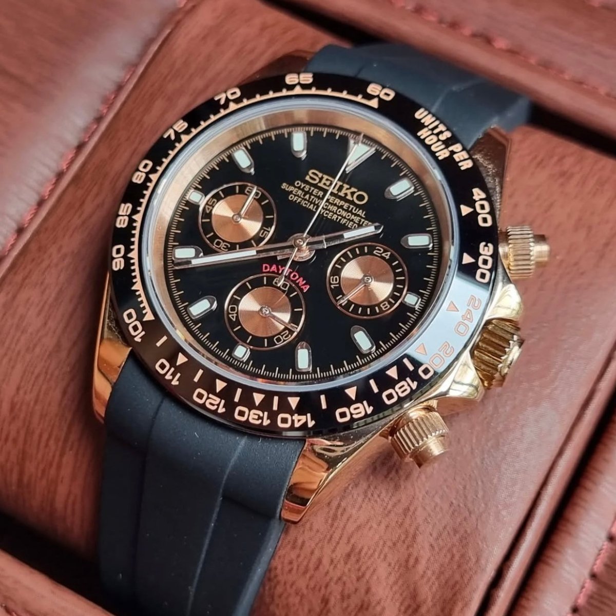 Chronographe méca-quartz ModTime de style Daytona — configuration aux tons or rose et noirs (VK63), cadran noir, poussoirs striés, vue en biais côté droit