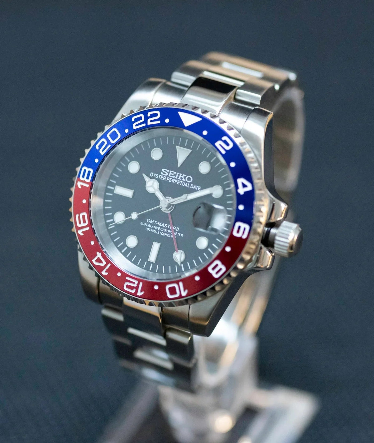 Montre automatique GMT — configuration «Pepsi» (NH34) avec lunette bleue et rouge et couronne striée, vue de trois quarts côté droit