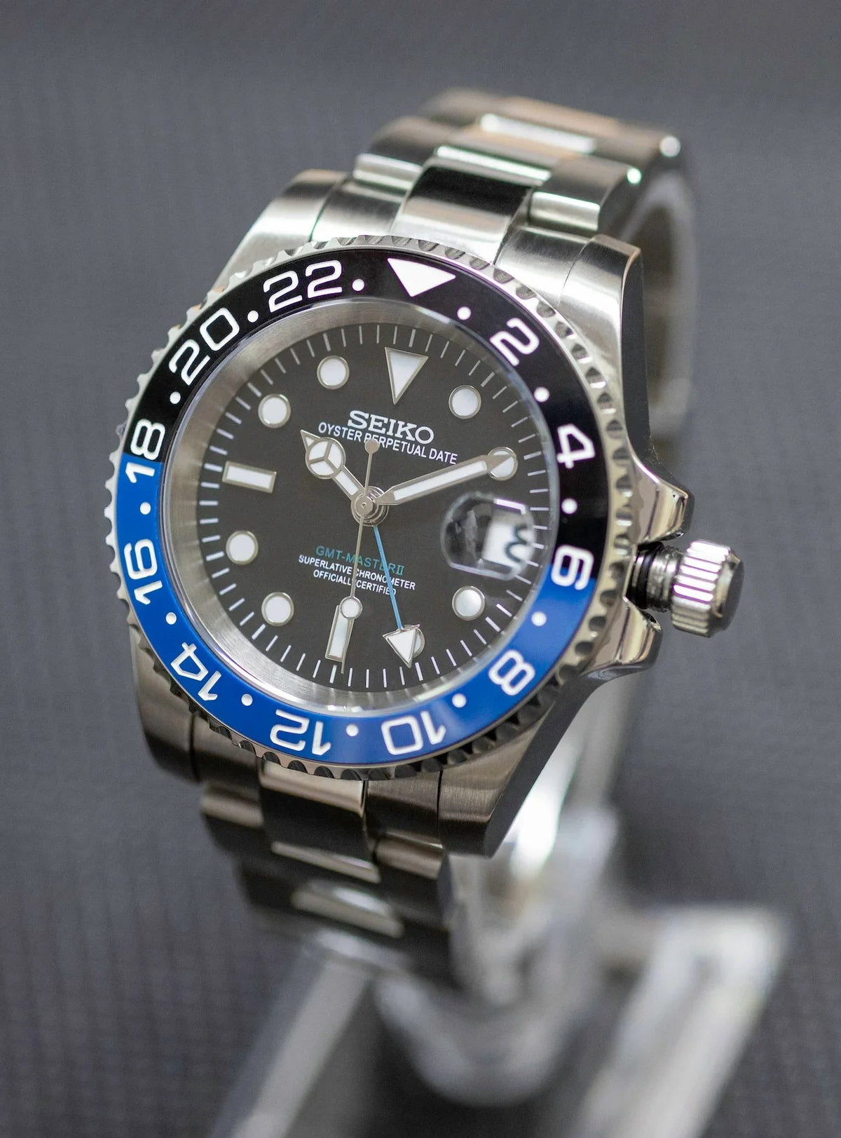 Montre automatique GMT — configuration «Batman» (NH34) avec lunette bleue et noire et couronne sortie, vue en biais du côté droit