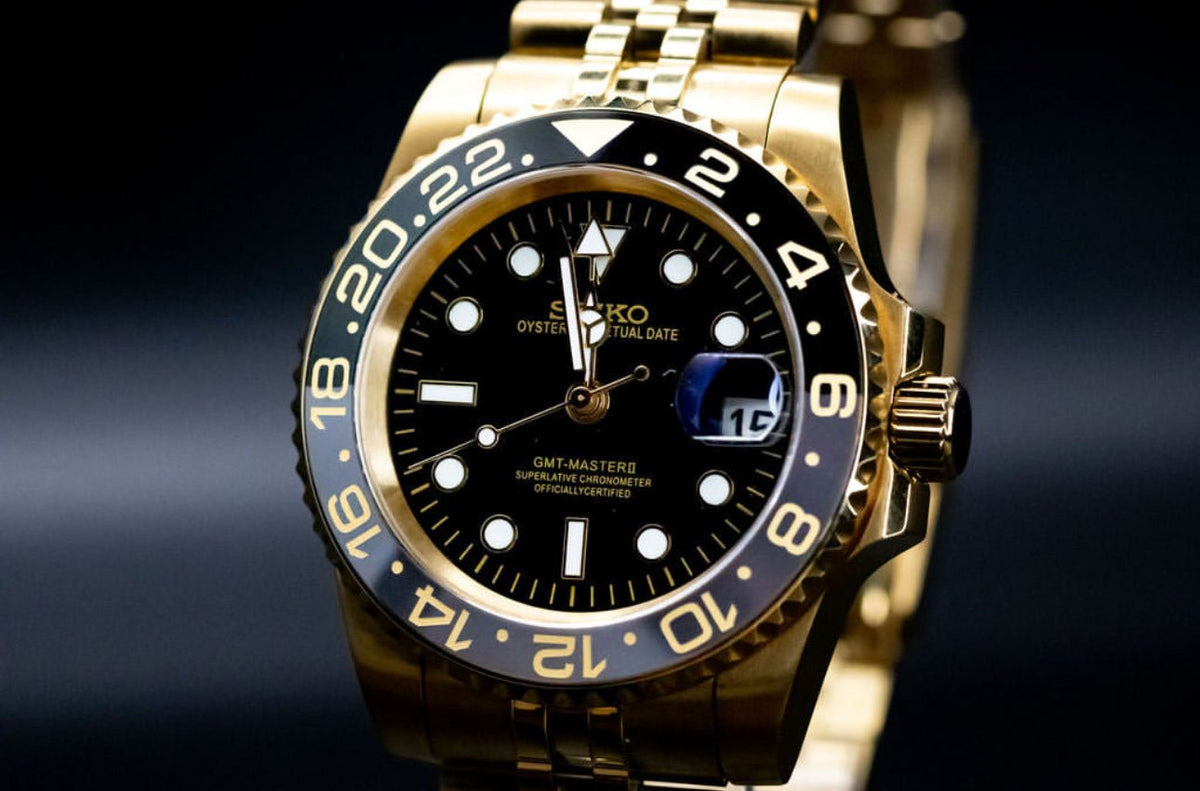 Montre automatique GMT — configuration aux tons dorés et noirs (NH34) avec cadran noir et loupe de date, gros plan en biais côté couronne