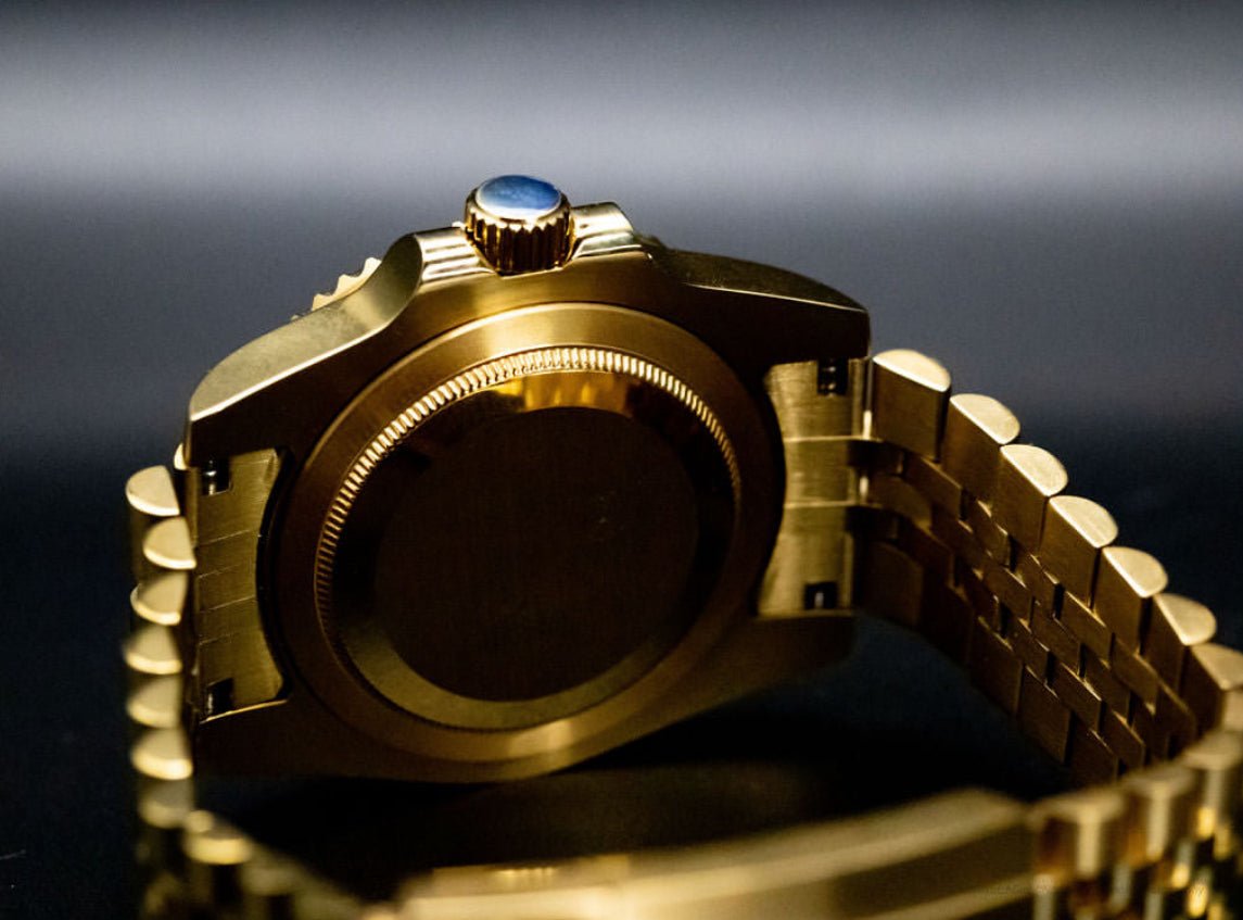 Montre automatique GMT — configuration aux tons dorés et noirs (NH34) avec boîtier aux tons dorés et fond de boîtier uni, gros plan arrière