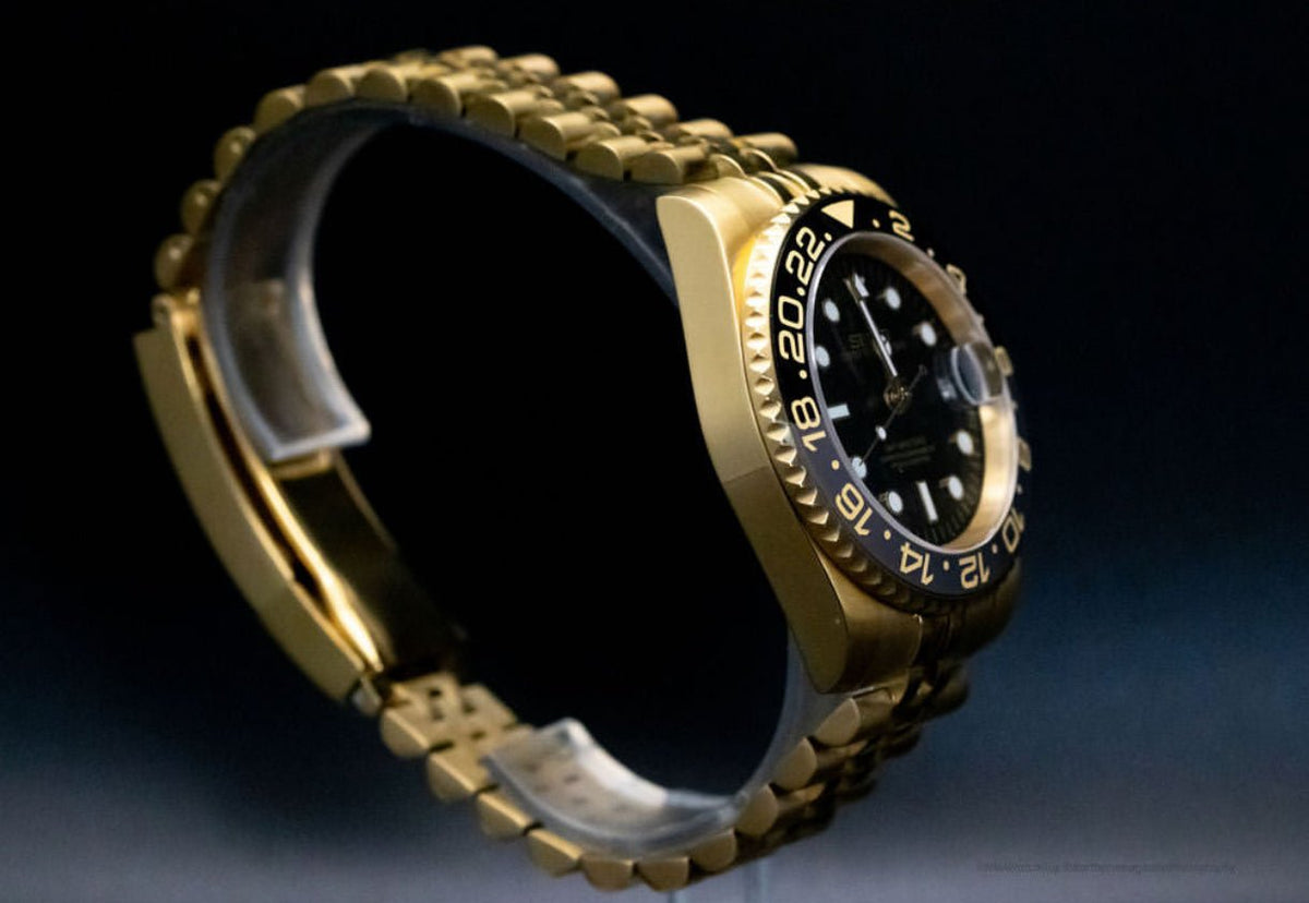 Montre automatique GMT — configuration aux tons dorés et noirs (NH34) avec boîtier aux tons dorés et bracelet de style Jubilee courbé, profil gauche