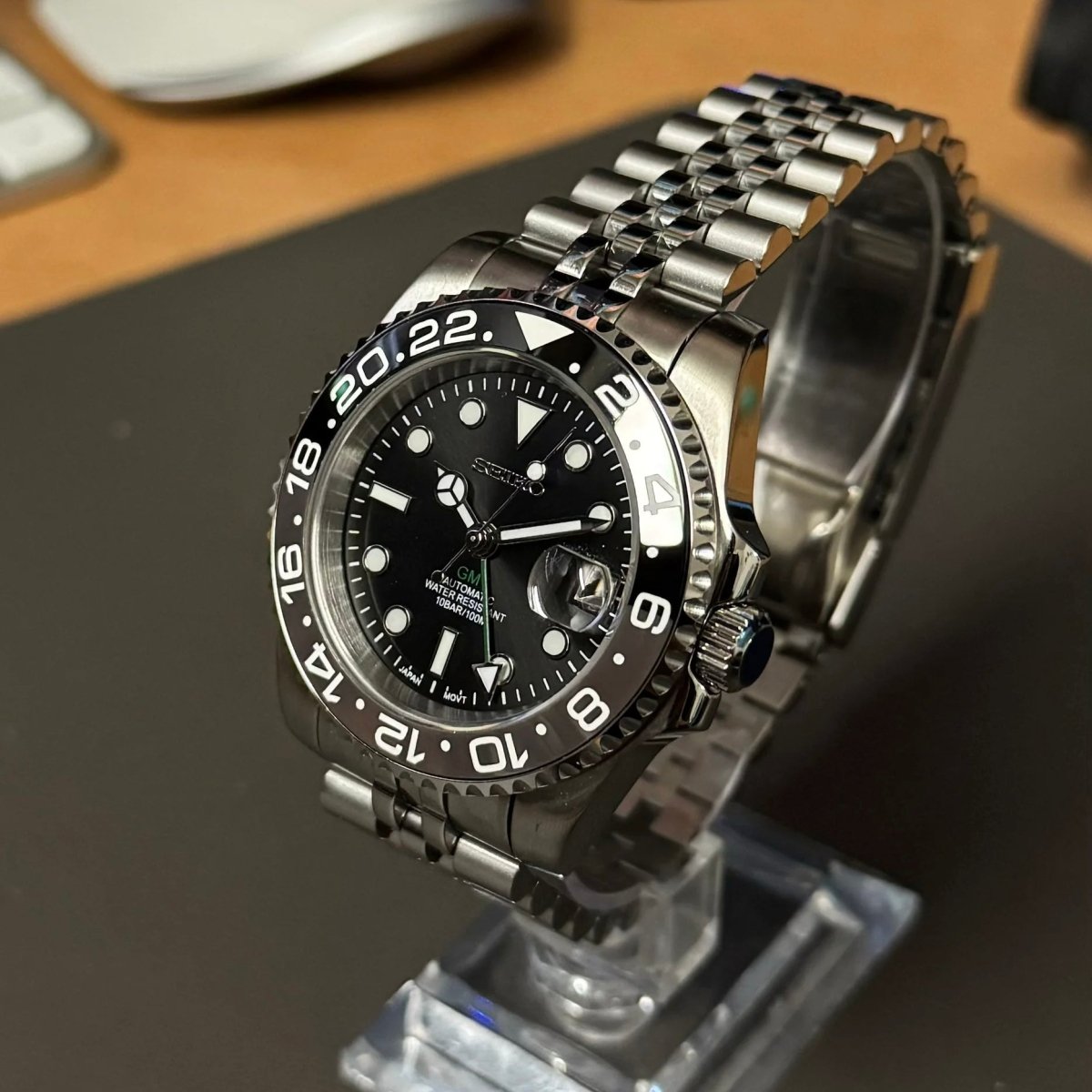 Montre automatique GMT — configuration «Bruce Wayne» (NH34) avec lunette grise et noire et couronne striée, vue en biais du côté droit