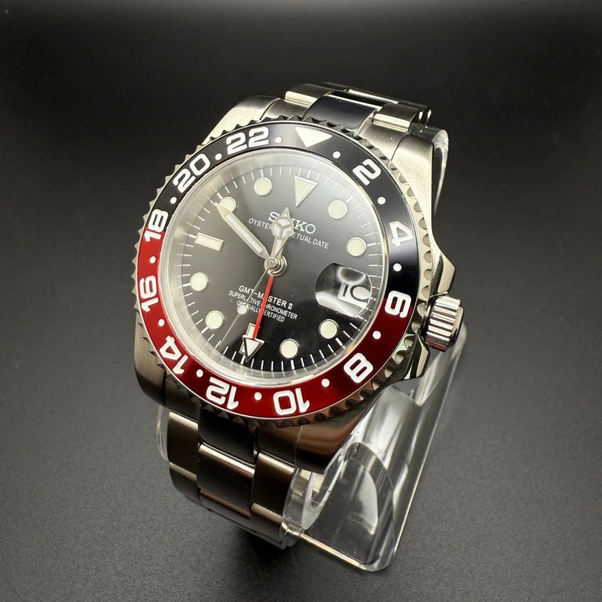Montre automatique GMT — configuration «Coke» (NH34) avec lunette noire et rouge et couronne striée, vue de trois quarts côté droit