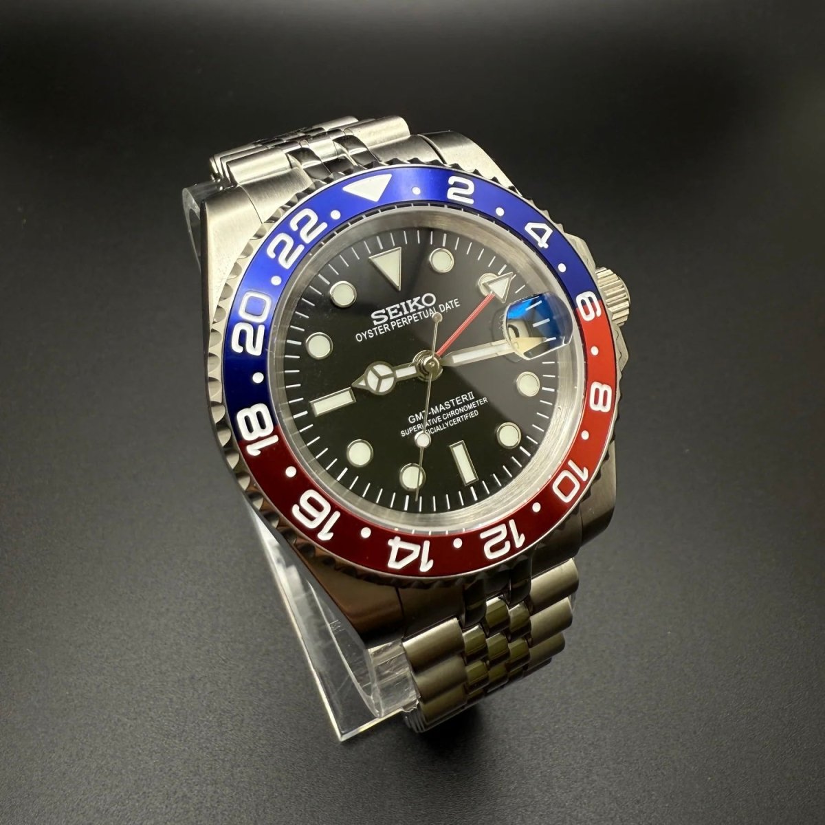 Montre automatique GMT — configuration «Pepsi» (NH34) avec cadran noir et bracelet de style Jubilee, vue en biais du côté gauche