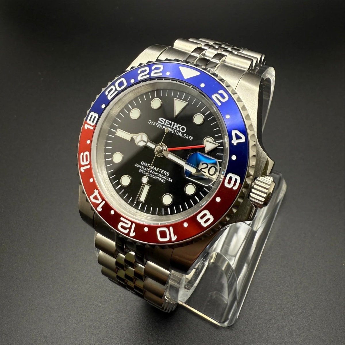 Montre automatique GMT — configuration «Pepsi» (NH34) avec lunette rouge et bleue et bracelet de style Jubilee, vue en biais côté couronne