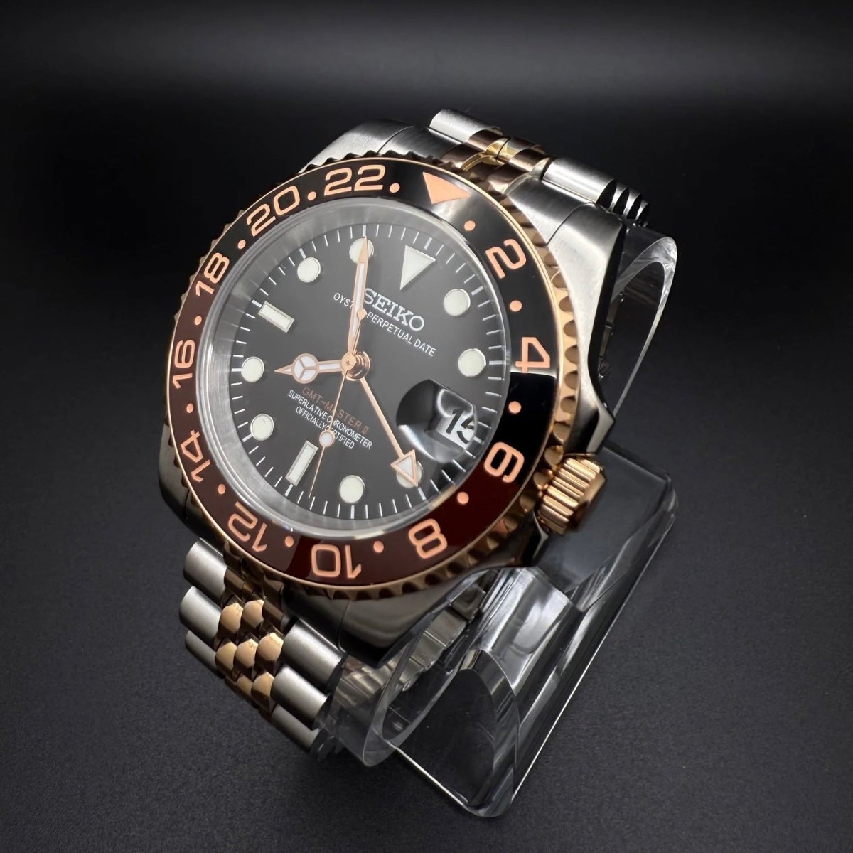 Montre automatique GMT — configuration «Root Beer», bicolore (NH34) avec couronne aux tons dorés et bracelet de style Jubilee, vue de trois quarts côté droit