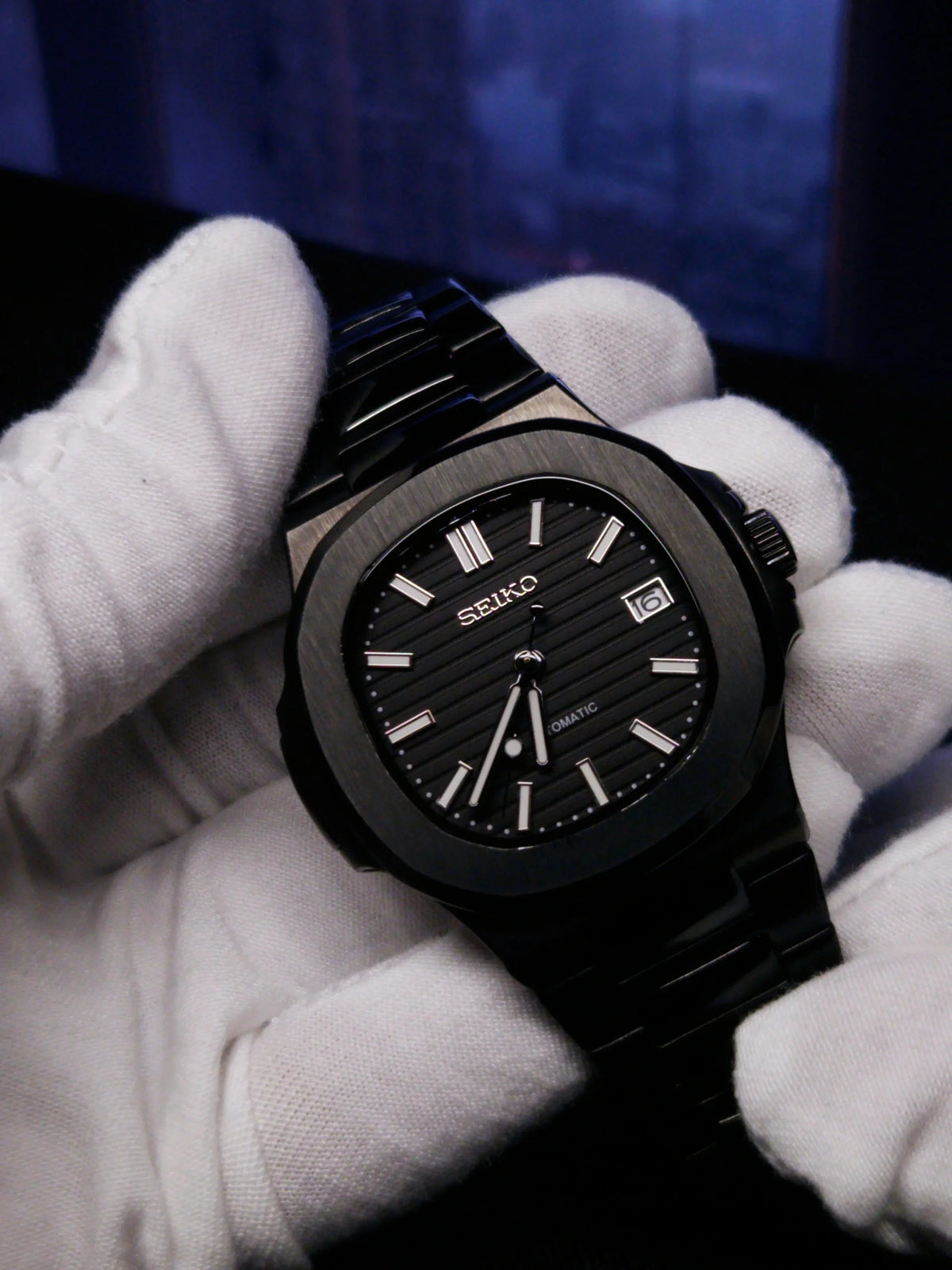 Montre automatique ModTime de style Nautilus — configuration entièrement noire (NH35), boîtier noir, guichet de date, dans un gant blanc