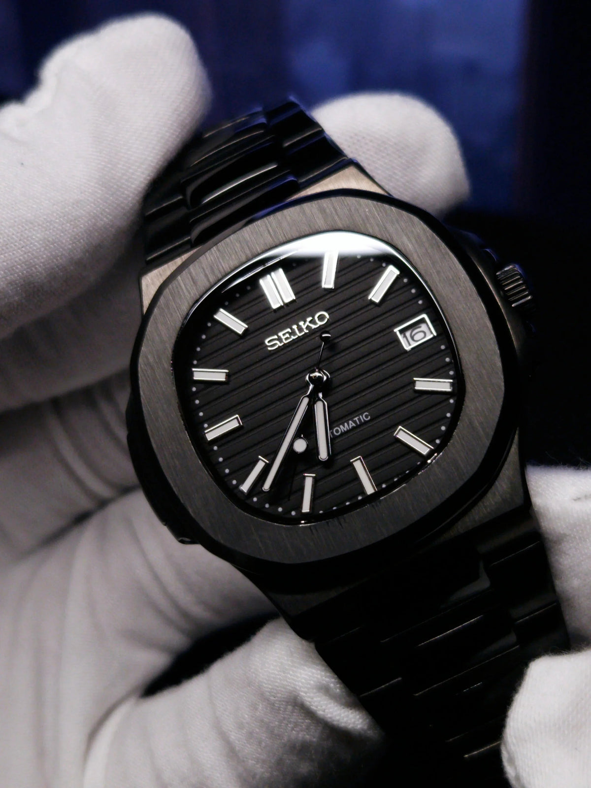 Montre automatique ModTime de style Nautilus — configuration entièrement noire (NH35), cadran noir, index bâtons, gros plan tenu en main