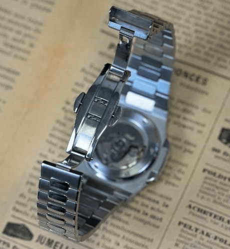 Montre automatique de style Nautilus — configuration cadran argenté (NH35) avec maillons aux tons argentés, fermoir ouvert, vue arrière depuis le dessus