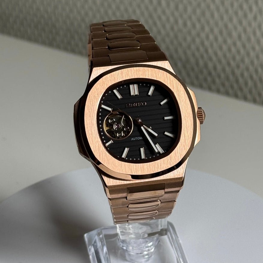 Montre automatique ModTime de style Nautilus — configuration aux tons or rose et noirs, cœur ouvert (NH38), cadran noir, index bâtons, sur un support