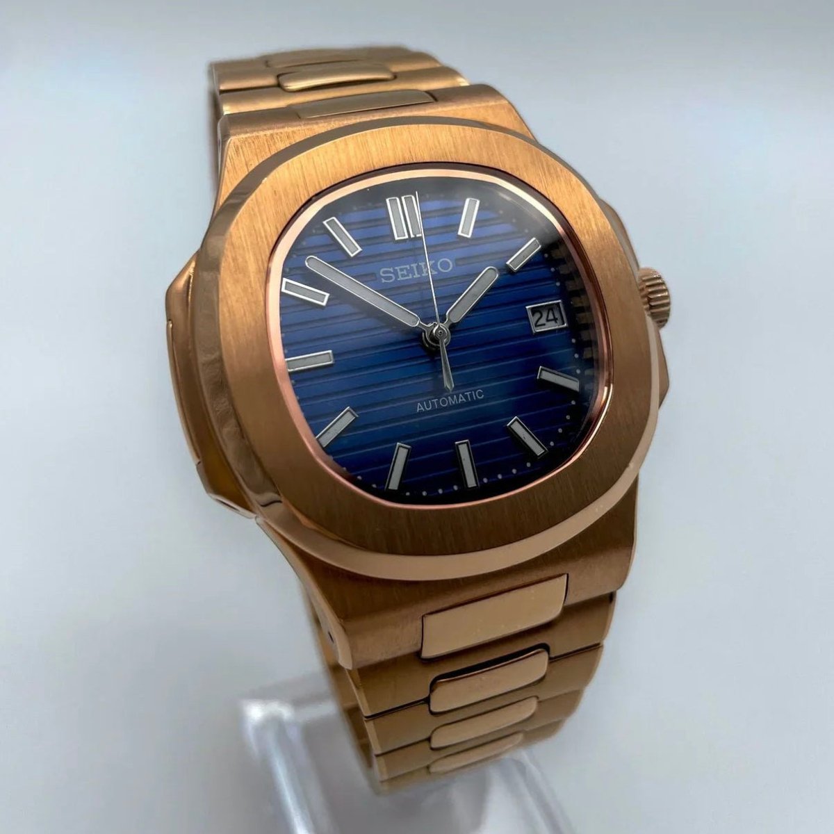 Montre automatique de style Nautilus — configuration cadran bleu (NH35) avec boîtier aux tons or rose, index bâtons, gros plan de face
