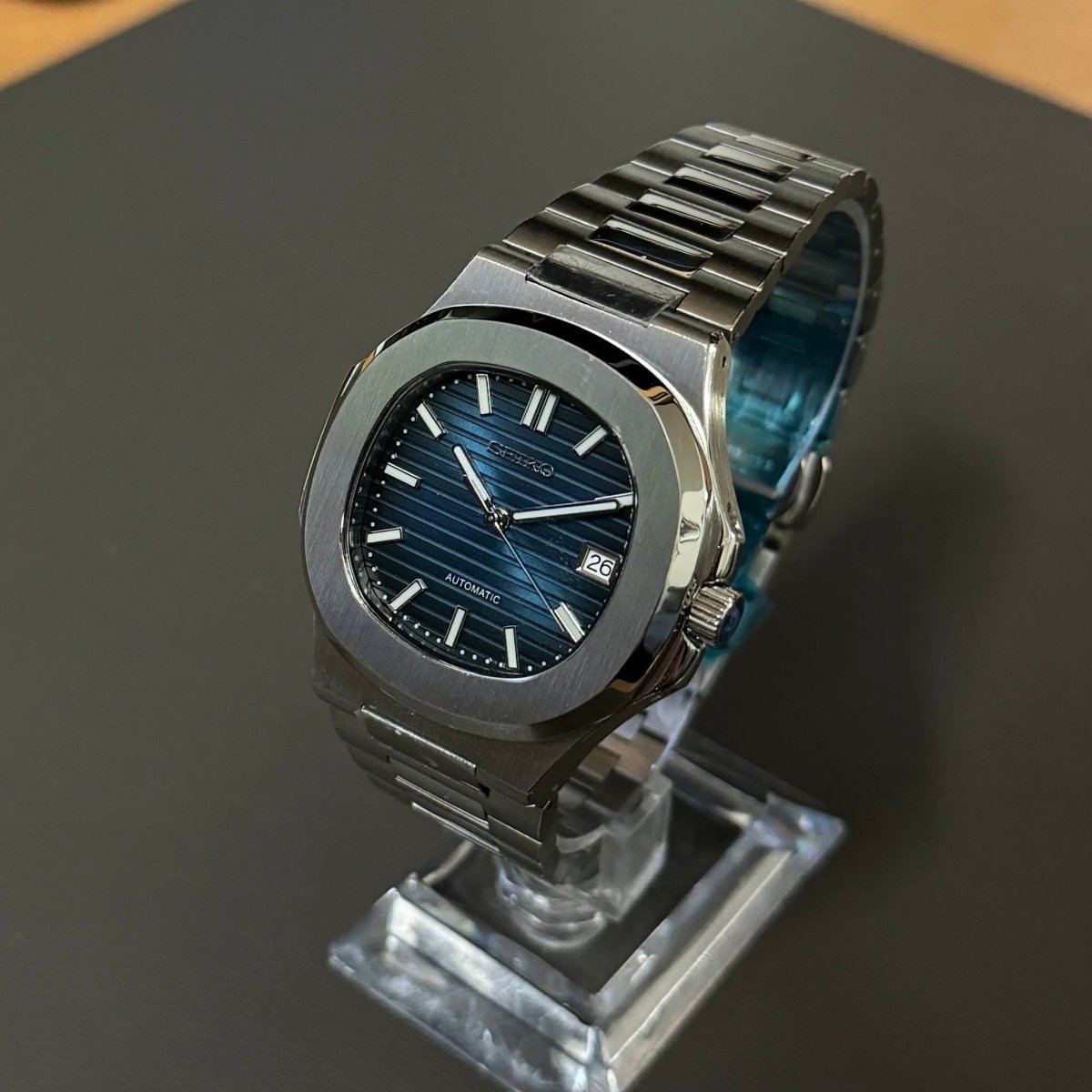 Montre automatique de style Nautilus — configuration argentée, cadran bleu (NH35) avec cadran bleu, couronne striée, vue en biais côté droit