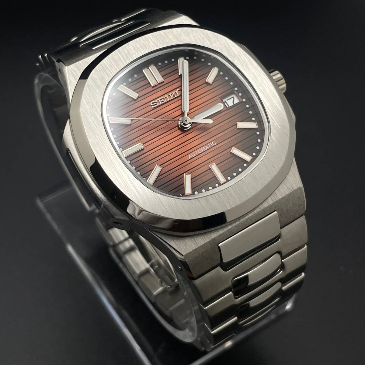 Montre automatique de style Nautilus — configuration argentée, cadran rouge cerise (NH35) avec maillons aux tons argentés, index bâtons, vue en biais côté gauche