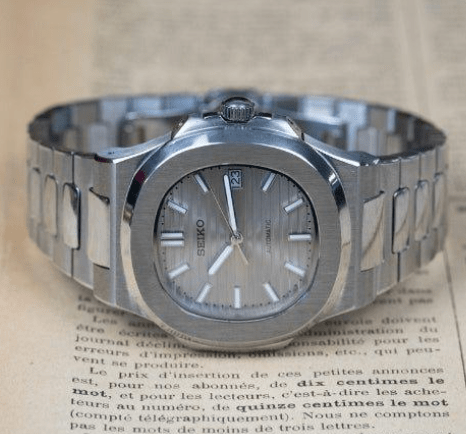 Montre automatique de style Nautilus — configuration cadran argenté (NH35) avec maillons aux tons argentés, lunette brossée, sur le côté sur du papier