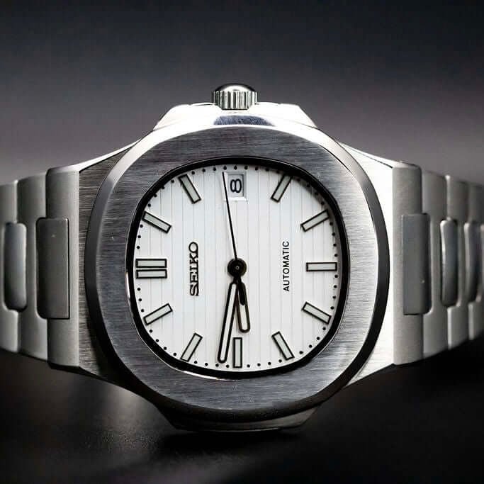 Montre automatique de style Nautilus — configuration argentée, cadran blanc neige (NH35) avec maillons aux tons argentés, guichet de date, posée sur le côté