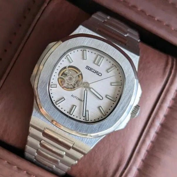 Montre automatique de style Nautilus — configuration cadran blanc à cœur ouvert (NH38) avec maillons aux tons argentés, lunette brossée, en diagonale dans une boîte