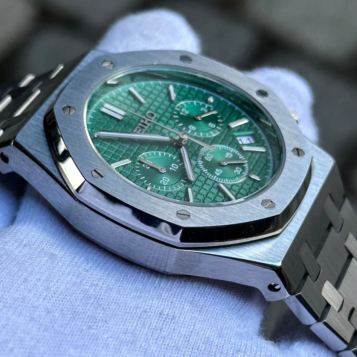 Chronographe méca-quartz ModTime de style Royal Oak — configuration argentée et verte (VK63), boîtier aux tons argentés, lunette brossée, vue depuis un angle bas