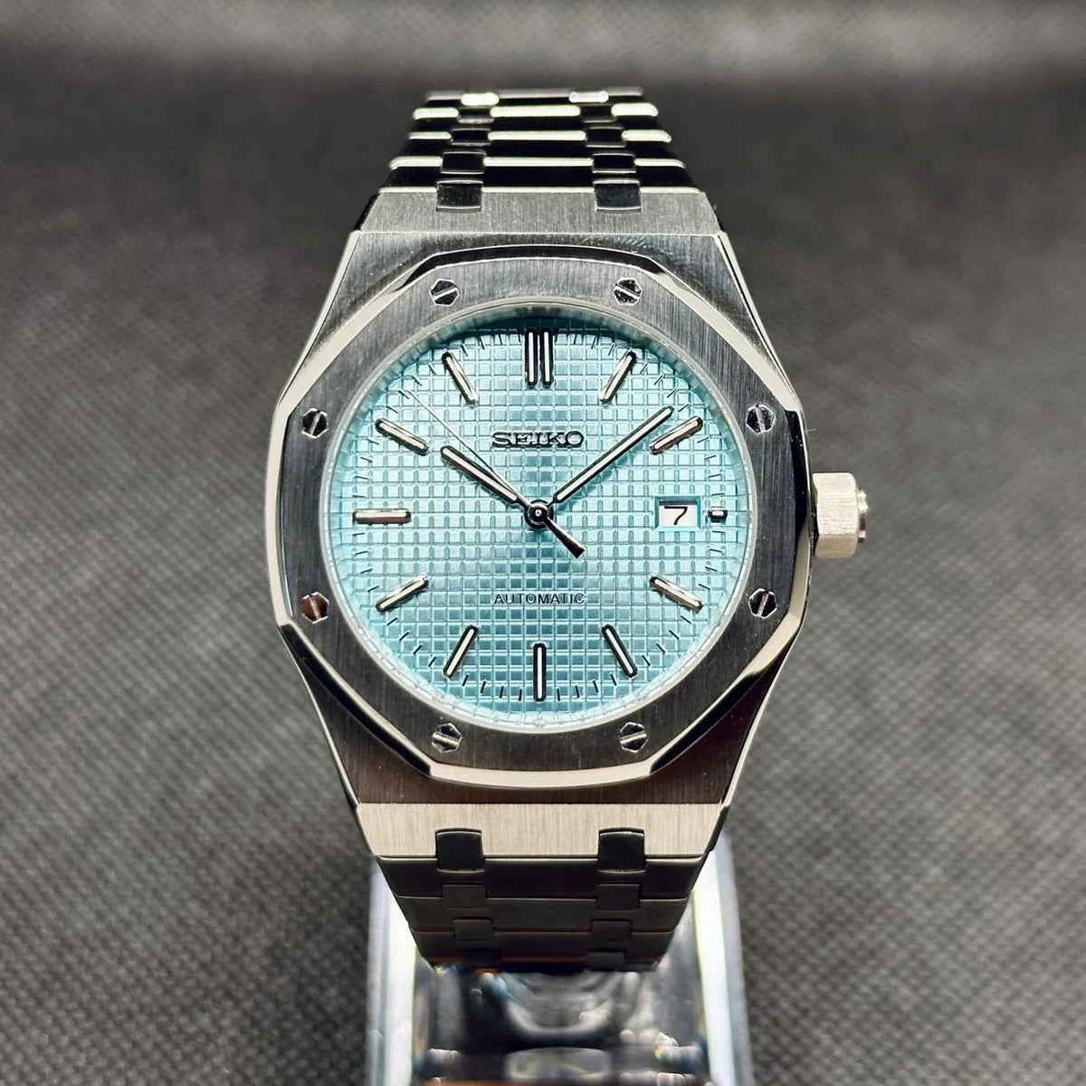 Montre automatique ModTime de style Royal Oak — configuration bleu clair (NH35), cadran bleu clair, texture quadrillée, vue de face sur un support