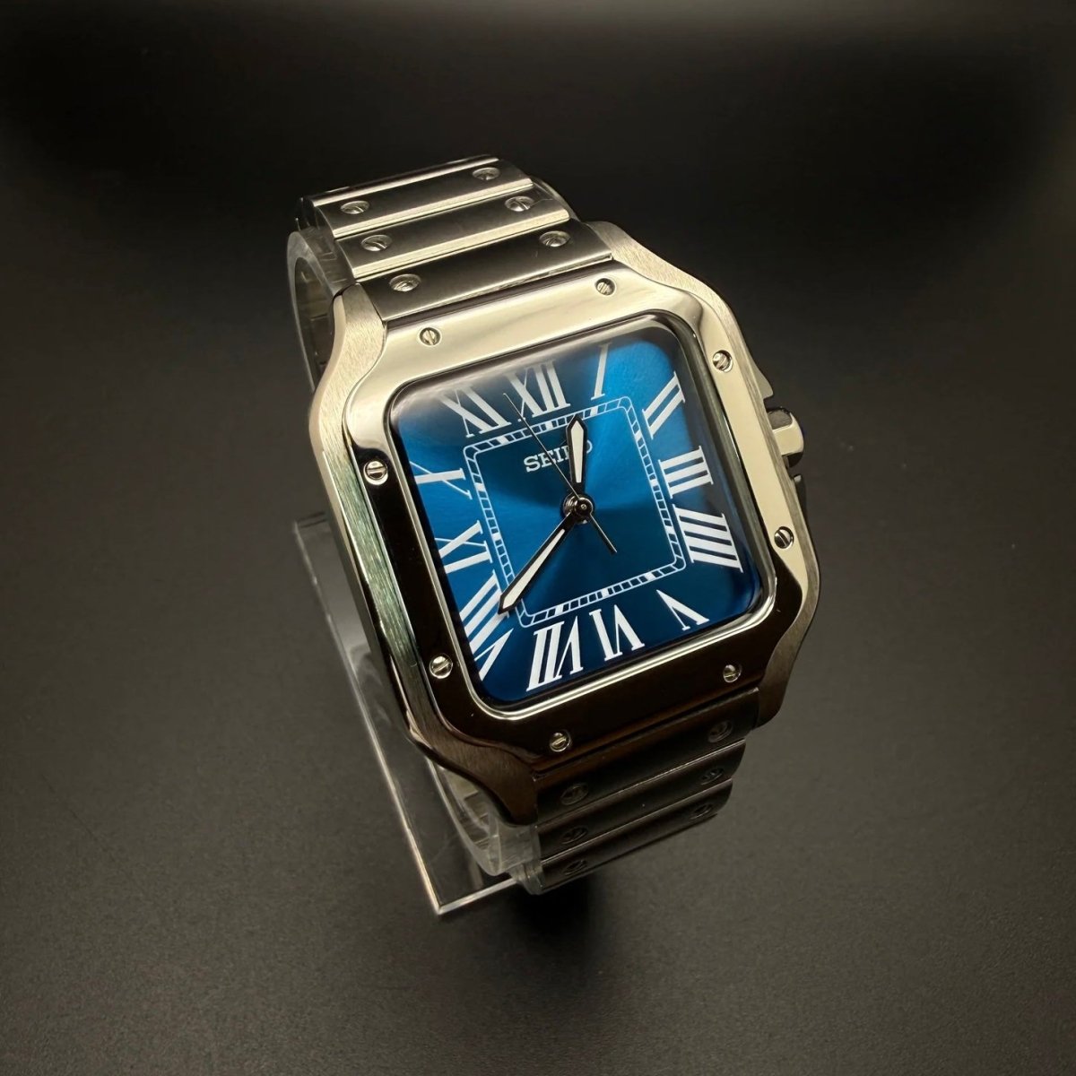Montre automatique ModTime de style Santos — configuration argentée et bleue (NH38), cadran bleu, vis de lunette, vue en biais depuis la gauche