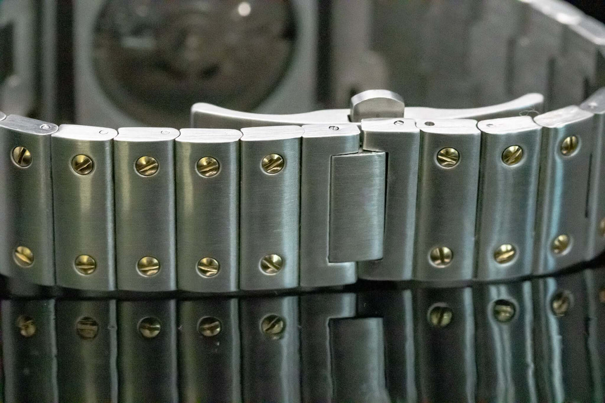 Montre automatique ModTime de style Santos — configuration bicolore et blanche (NH38), bracelet aux tons argentés, vis aux tons dorés, gros plan du fermoir