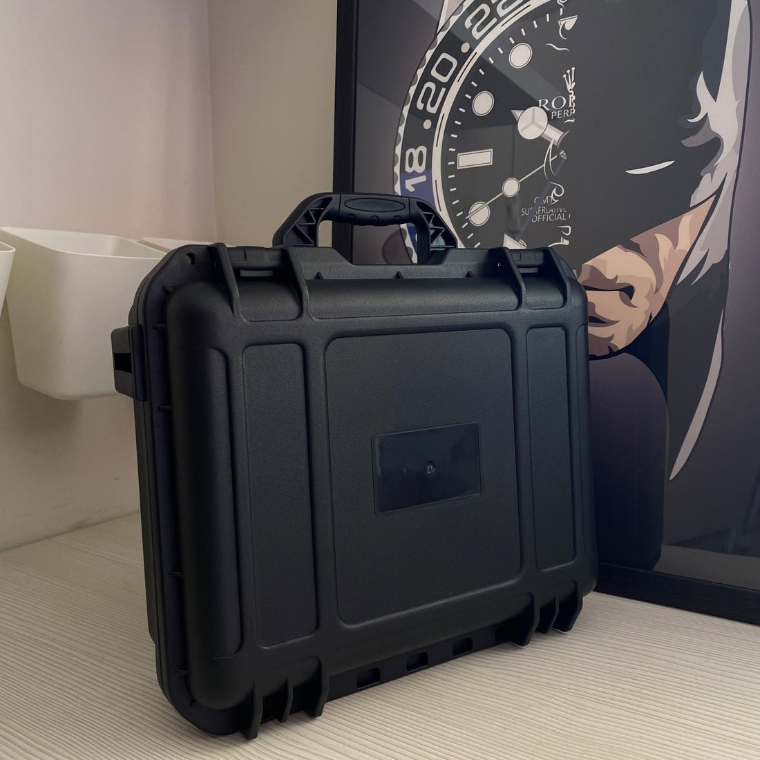 Boîte Watch Security Box noire ModTime, coque extérieure striée et poignée de transport relevée, debout sur un bureau