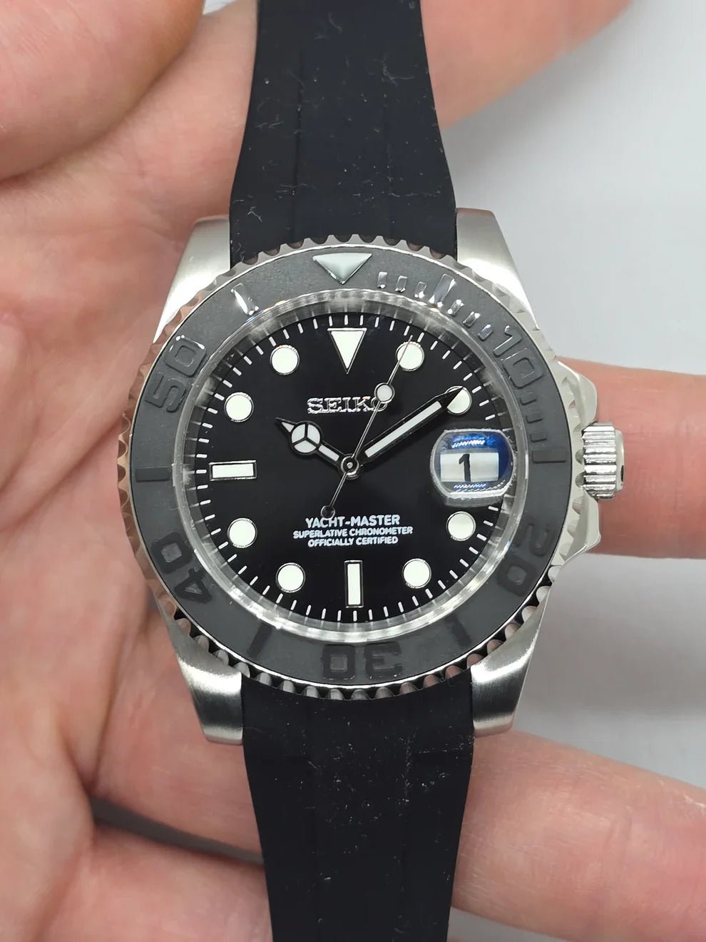 Montre automatique ModTime de style Yachtmaster — configuration cadran noir et bracelet en caoutchouc (NH35), cadran noir, index blancs, vue de face tenue en main