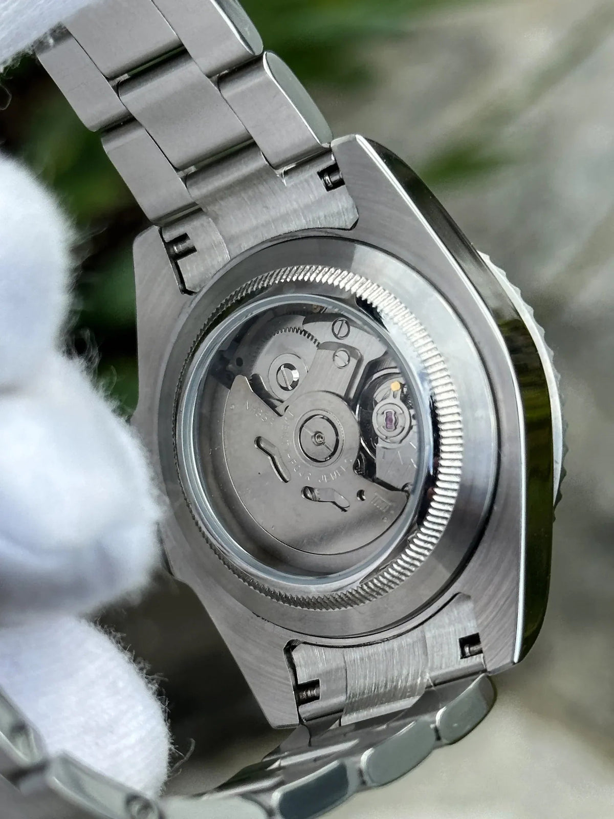 Montre automatique ModTime de style Yachtmaster — configuration cadran gris (NH35), boîtier aux tons argentés, rotor visible, gros plan arrière tenu dans une main gantée