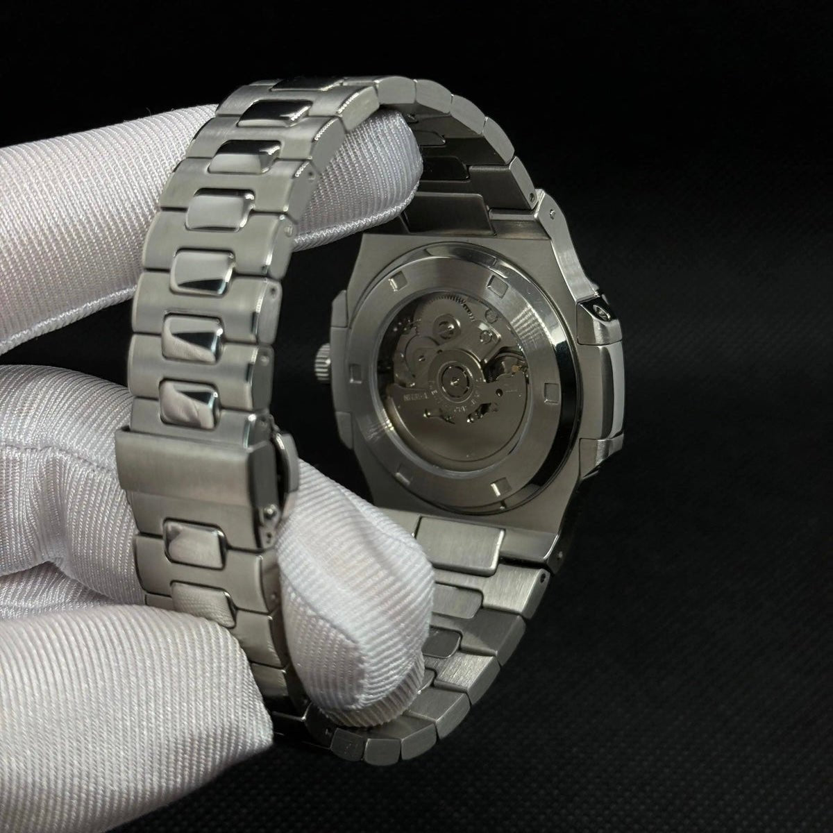 ModTime Nautilus-style Silver Skeleton listing (NH38): silver-tone caseback, rotor marked NH35A, gloved rear view
