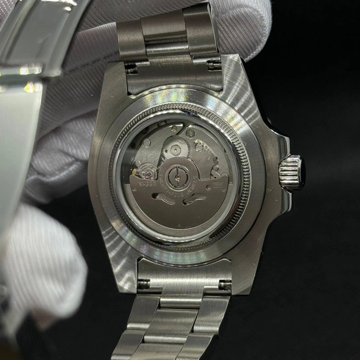 Fiche du modèle ModTime de style Submariner — configuration argentée et bleu ciel (NH35) : boîtier aux tons argentés, rotor portant l'inscription NH35A, vue arrière tenue dans une main gantée